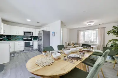 a kitchen and dining room with a wooden table at Stunning Poconos Villa- Hot Tub, Pool, Game Room, BBQ & more in East Stroudsburg