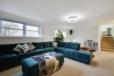 a living room with a blue couch and a table at Stunning Poconos Villa- Hot Tub, Pool, Game Room, BBQ & more in East Stroudsburg