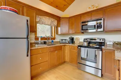 a kitchen with wooden cabinets and a white refrigerator at Pet-Friendly Hancock Home on the Delaware River! in Starlight
