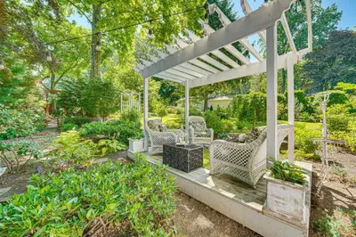 a white pergola with chairs in a garden at 3 Mi to Lake Redman Home with Furnished Pergola! in York