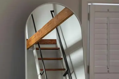 a spiral staircase in front of a mirror at Brooke House In The Heart of Downtown with Patio! in Lambertville