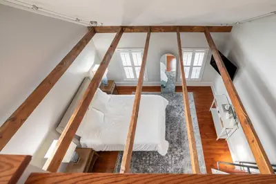 a room with a white bed in the attic at Brooke House In The Heart of Downtown with Patio! in Lambertville