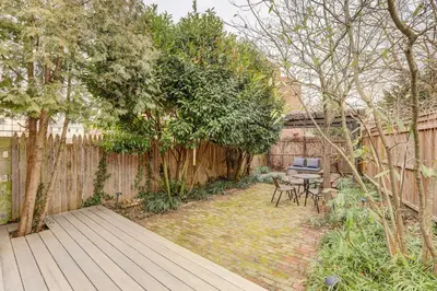 a backyard with a wooden deck and a table and chairs at Brooke House In The Heart of Downtown with Patio! in Lambertville