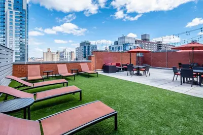 a rooftop patio with chairs and tables and grass at UWS 1BR w Doorman Gym Parking nr Central Park NYC-596 in New York