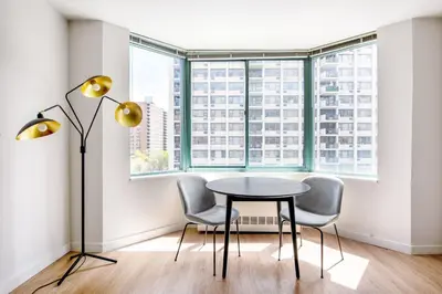 a table and two chairs in a room with a window at UWS 1BR w Doorman Gym Parking nr Central Park NYC-596 in New York