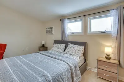 a bedroom with a bed with a blue comforter and two windows at Wilmington Vacation Rental Less Than 2 Mi to Downtown! in Wilmington