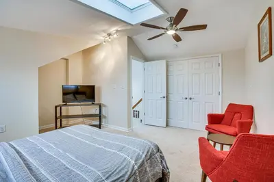 a bedroom with a bed and two red chairs at Wilmington Vacation Rental Less Than 2 Mi to Downtown! in Wilmington