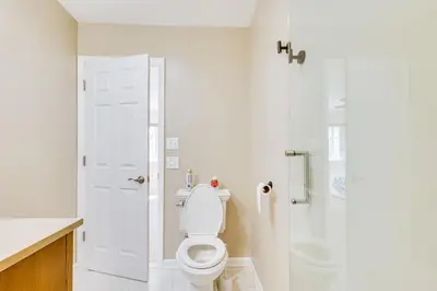 a white bathroom with a toilet and a shower at Wilmington Vacation Rental Less Than 2 Mi to Downtown! in Wilmington