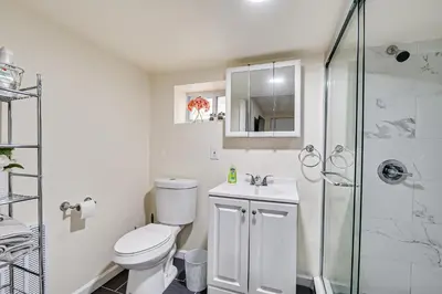 a white bathroom with a toilet and a shower at Quite and Spacious Apartment in Elizabeth