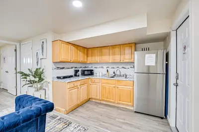 a kitchen with wooden cabinets and a refrigerator at Quite and Spacious Apartment in Elizabeth