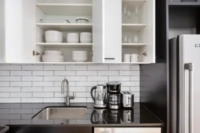 a kitchen counter with a sink and white cabinets at FiDi 1br w lounge gym nr Freedom Tower NYC-1138 in New York