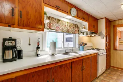a kitchen with wooden cabinets and a sink and a window at Scenic Home on the Delaware River, Pet-Friendly! in Starlight