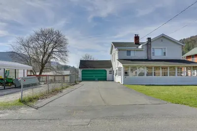a white house with a green garage at Scenic Home on the Delaware River, Pet-Friendly! in Starlight