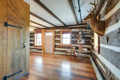 a room with a table and a deer head on the wall at Rustic Wellsville Home - 5 Mi to Roundtop Mountain in Wellsville