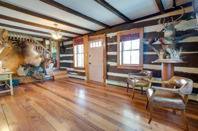 a living room with wooden floors and a room with a table and chairs at Rustic Wellsville Home - 5 Mi to Roundtop Mountain in Wellsville
