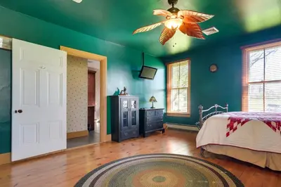 a bedroom with green walls and a ceiling fan at Rustic Wellsville Home - 5 Mi to Roundtop Mountain in Wellsville
