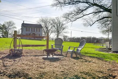 three chairs and a table in a yard with a house at Rustic Wellsville Home - 5 Mi to Roundtop Mountain in Wellsville