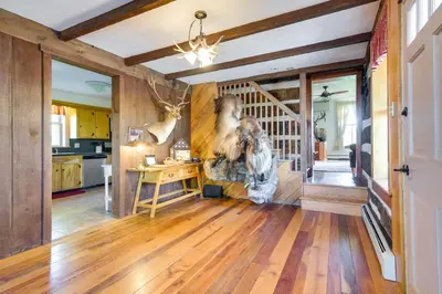 a kitchen with wooden floors and a staircase in a house at Rustic Wellsville Home - 5 Mi to Roundtop Mountain in Wellsville
