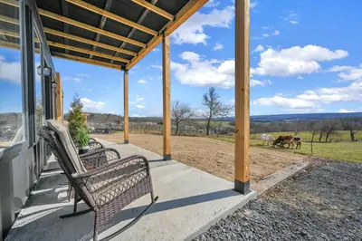a porch with two benches and horses in the field at ‘Scenic Escapes’ Romantic Pine Grove Getaway! in Pine Grove