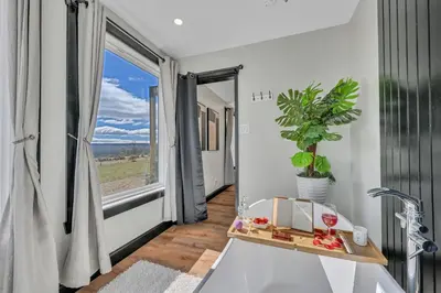 a bathroom with a large window and a sink at ‘Scenic Escapes’ Romantic Pine Grove Getaway! in Pine Grove