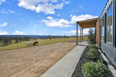 a barn conversion with a dirt road next to a house at ‘Scenic Escapes’ Romantic Pine Grove Getaway! in Pine Grove