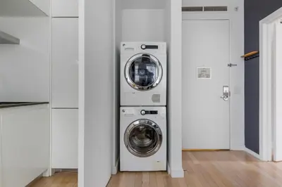a laundry room with a washer and dryer in it at Midtown 1br w doorman gym wd nr Rock Center NYC-1127 in New York