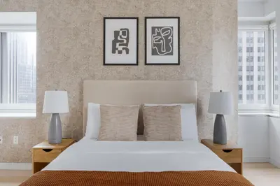 a bedroom with a white bed with two lamps at Midtown 1br w doorman gym wd nr Rock Center NYC-1127 in New York