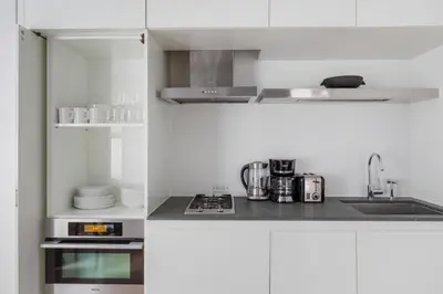 a white kitchen with a sink and a stove at Midtown 1br w doorman gym wd nr Rock Center NYC-1127 in New York