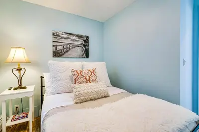 a bedroom with a bed with a blue wall at New Jersey Abode - Near Theme Parks, Walk to Beach in Keansburg