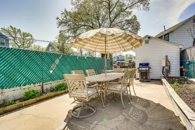 a table and chairs with an umbrella on a patio at New Jersey Abode - Near Theme Parks, Walk to Beach in Keansburg