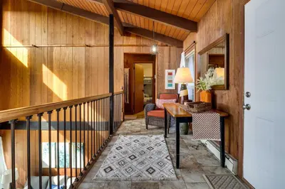 a hallway of a home with wooden walls and a staircase at Dock and Fire Pit Lakefront Poconos Retreat! in Long Pond
