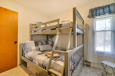 a bedroom with two bunk beds and a window at Dock and Fire Pit Lakefront Poconos Retreat! in Long Pond