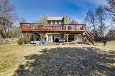 a house with a deck on top of it at Dock and Fire Pit Lakefront Poconos Retreat! in Long Pond
