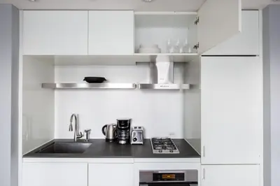 a kitchen with white cabinets and a sink at Midtown 1br w doorman gym wd nr Rock Center NYC-1131 in New York