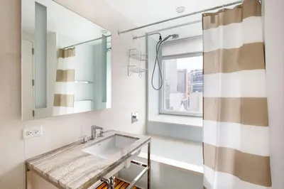 a bathroom with a sink and a window at Midtown 1br w doorman gym wd nr Rock Center NYC-1131 in New York