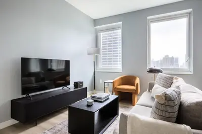 a living room with a couch and a flat screen tv at Midtown 1br w doorman gym wd nr Rock Center NYC-1131 in New York