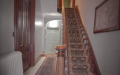 a stairway with a wooden railing in a hallway at Shamokin Bed and Breakfast in Shamokin