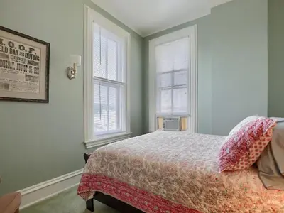 a bedroom with a bed and two windows at Shamokin Bed and Breakfast in Shamokin