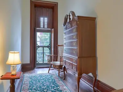 a room with a dresser and a chair and a lamp at Shamokin Bed and Breakfast in Shamokin