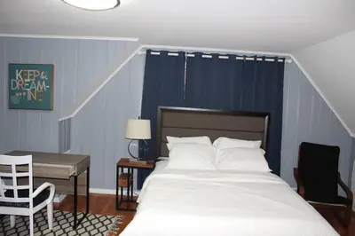 a bedroom with a bed and a desk and a chair at Beautiful place minutes away to New York City . in Teaneck