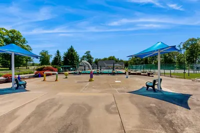 a playground with benches and blue umbrellas in a park at 226 E Shore Dr in East Stroudsburg