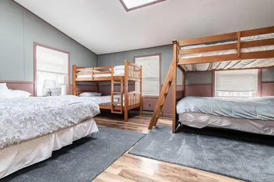 two beds in a room with two bunk beds at Waterfront Stagshead Lakehouse at Lake Arrowhead in Arrowhead Lake
