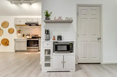 a kitchen with white cabinets and a white door at 7 Mi to Whitewater Rafting Cozy Lansford Cabin! in Barnesville