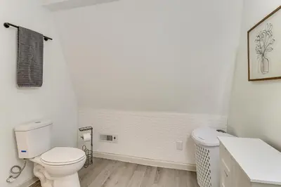 a white bathroom with a toilet and a sink at 7 Mi to Whitewater Rafting Cozy Lansford Cabin! in Barnesville