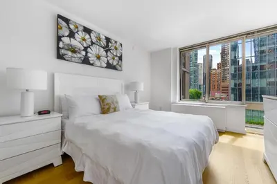 a white bedroom with a white bed and a window at Global Luxury Suites at The Marc in New York