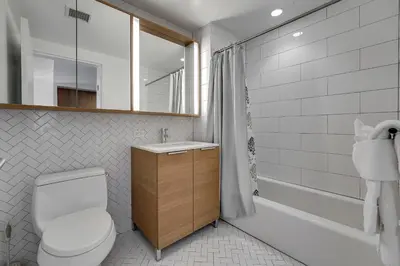 a bathroom with a toilet and a sink and a tub at Global Luxury Suites at Via 57 in New York