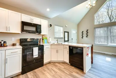 a kitchen with white cabinets and black appliances at Hike and Ski Pocono Lake Home with Community Perks! in Pocono Lake
