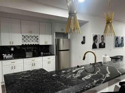 a kitchen with a black counter top and a refrigerator at Luxe Lrg Pocono House for 18 Hot Tub/Gameroom/Pool in Kunkletown