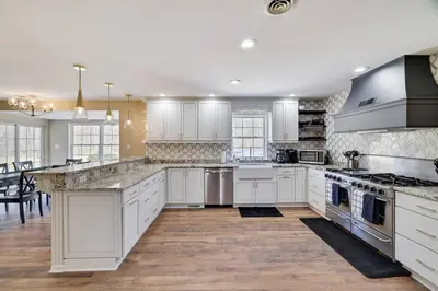 a large kitchen with white cabinets and a large island at Luxe Lrg Pocono House for 18 Hot Tub/Gameroom/Pool in Kunkletown