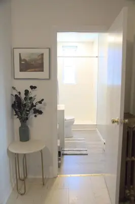 a bathroom with a toilet and a table and a window at Charming Victorian Home In Historic District in Newburgh
